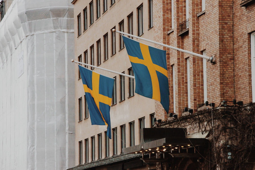 två svenska flaggor i en svensk stad